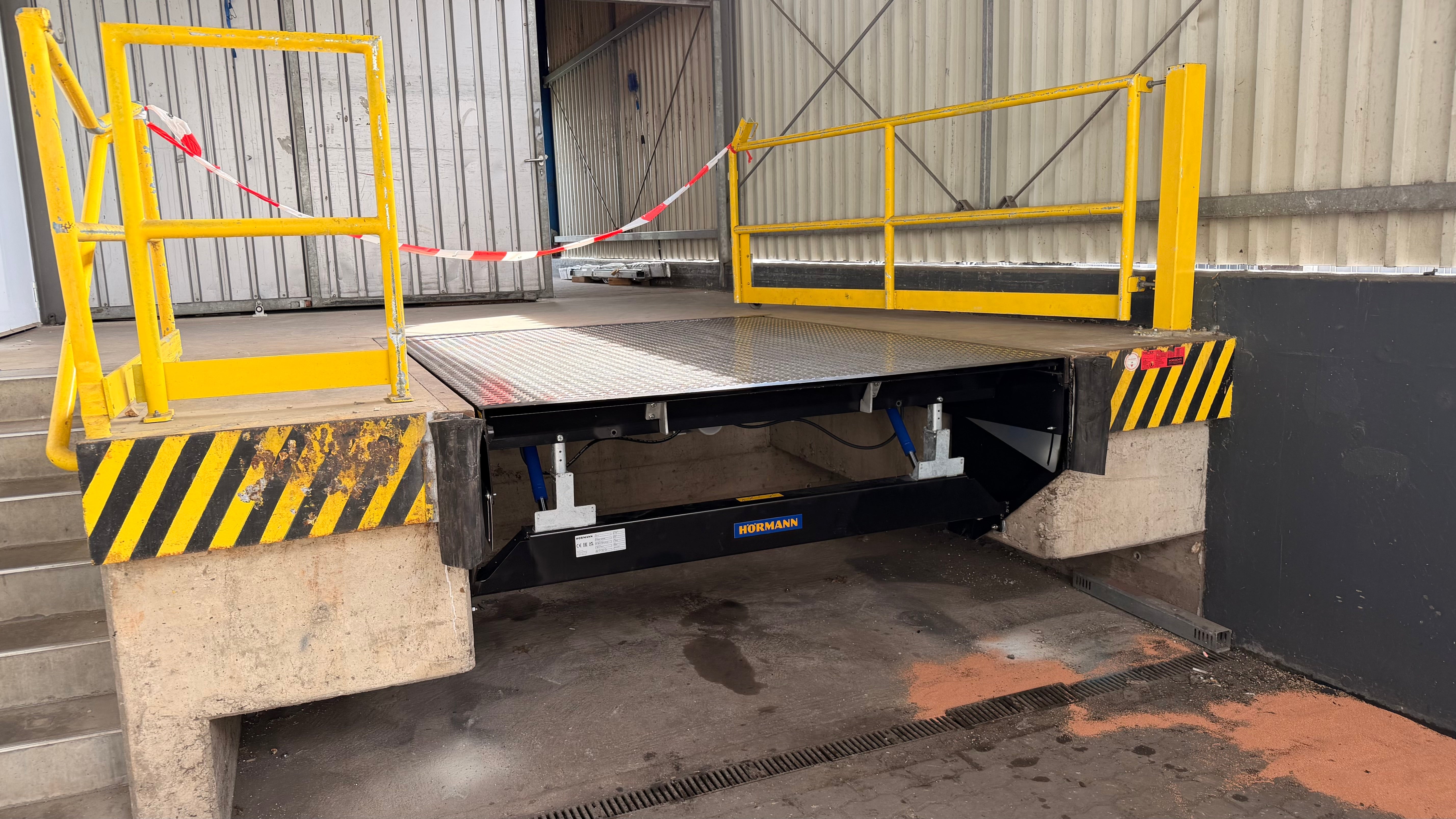 Überladebrücke mit Hydrauliköl-Leck an Schlauch und Zylinder – passende Hydraulikschläuche, Adapter und Hydrauliköl für Verladetechnik von Tormeister24.